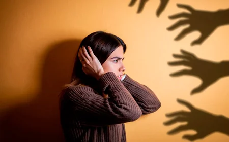 Девушка стоит на фоне оранжевой стены